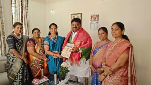 కొలన్ హన్మంత్ రెడ్డికి ఆహ్వాన పత్రిక అందజేస్తున్న నిర్వాహకులు