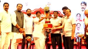 Teenmar Mallanna receiving a trophy at sports meet