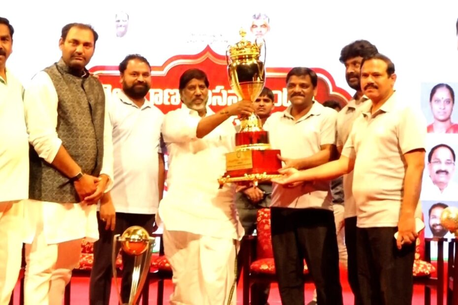 Teenmar Mallanna receiving a trophy at sports meet